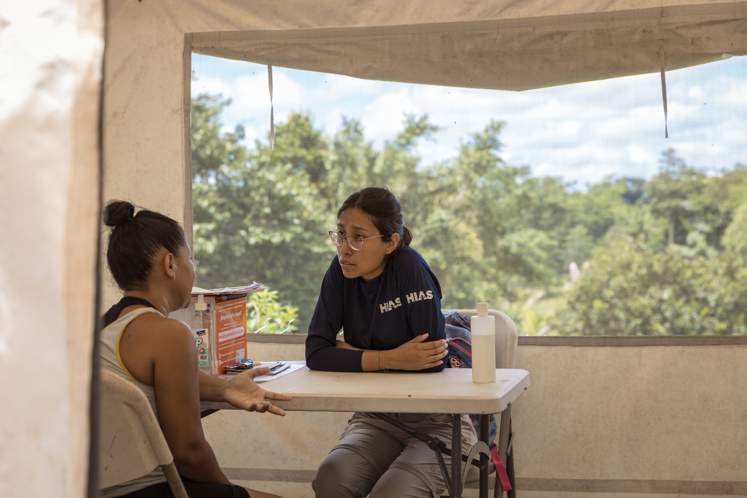 Darien Field Manager Daniela Montesinos talks with woman migrant at the Migration Reception Center in Lajas Blancas. Darien province, Panama. August 1, 2023.
